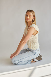 side view of sleeveless crochet cream top with ruffles and lace trim