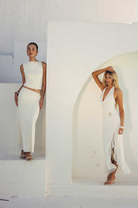 Two women wearing white dresses against a white background