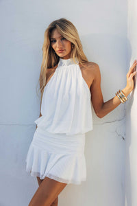 white-image | Woman wearing a white dress against a light blue wall
