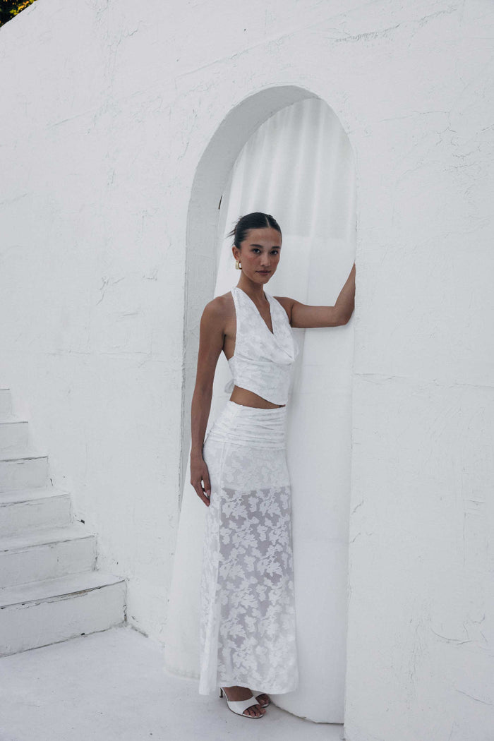 Woman in a white dress standing in a white architectural setting