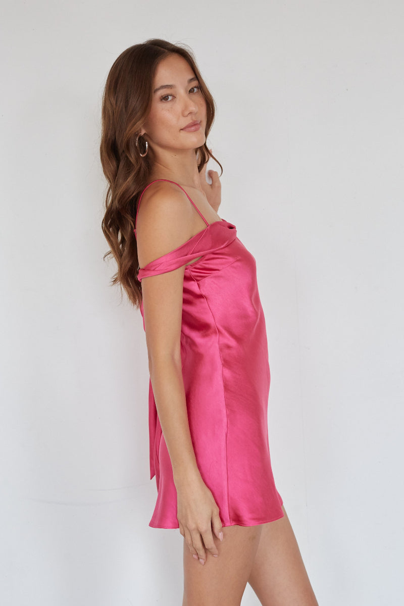 Woman wearing a pink satin dress against a white background