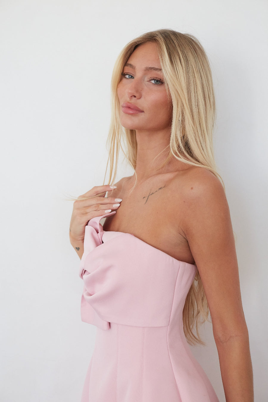 Woman wearing a pink dress against a white background