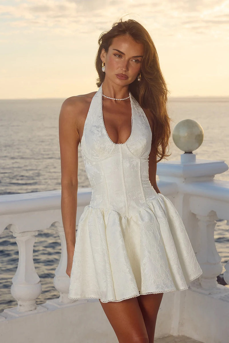 white-image | Woman in a white dress standing by a railing with a scenic background