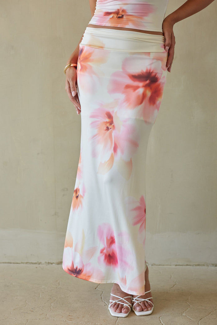 Woman wearing a floral skirt with a plain background