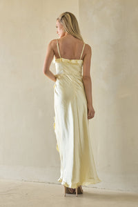 Woman wearing a light yellow dress against a plain background