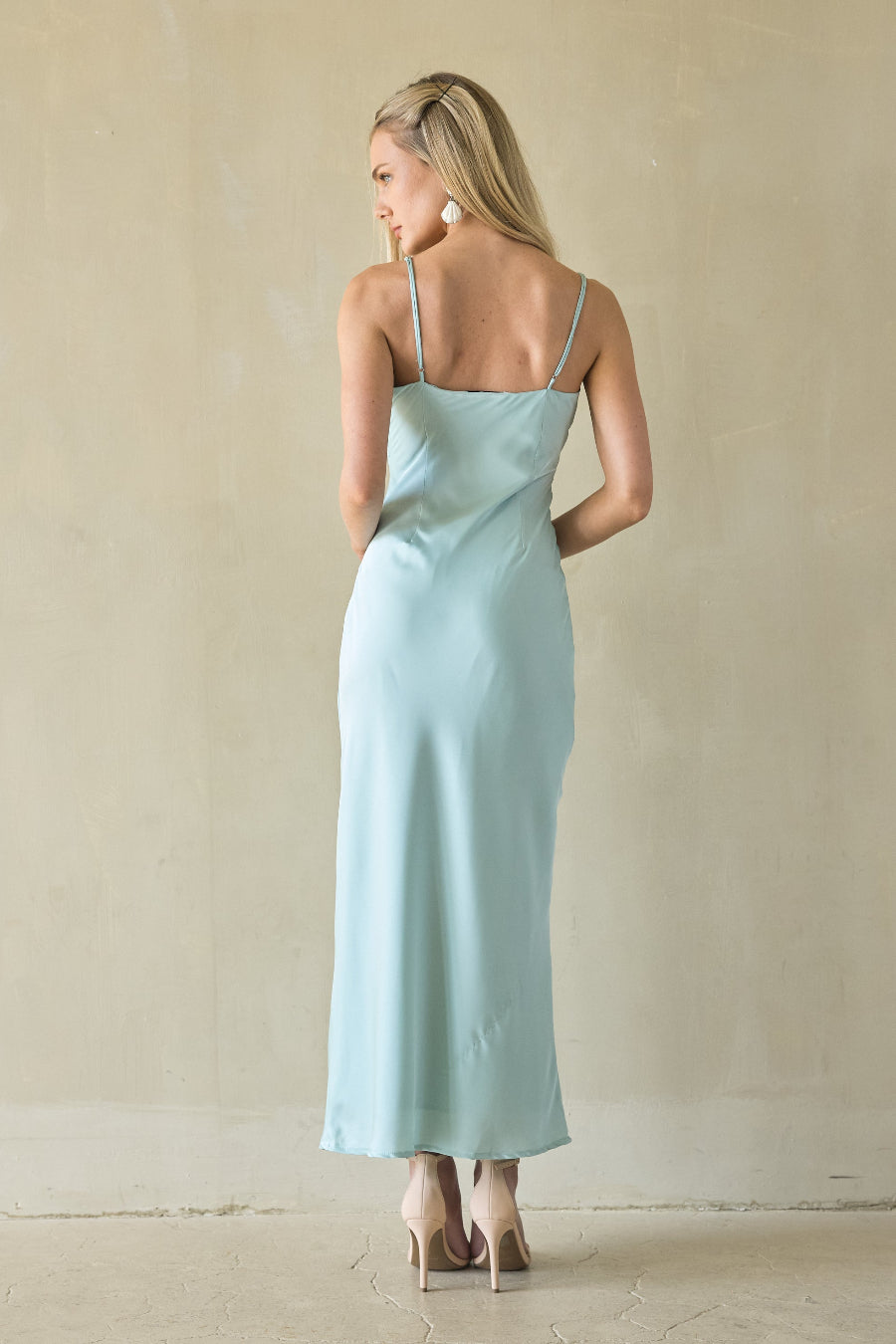 Woman wearing a light green dress against a plain background