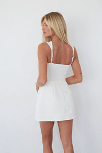 Woman wearing a white dress against a plain background