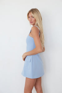 Woman wearing a light blue dress against a white background