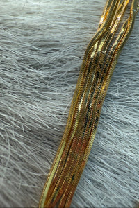 overhead-image | gold chain necklace | modern layered style | bird's-eye view of a layered gold chain necklace with twisted designs