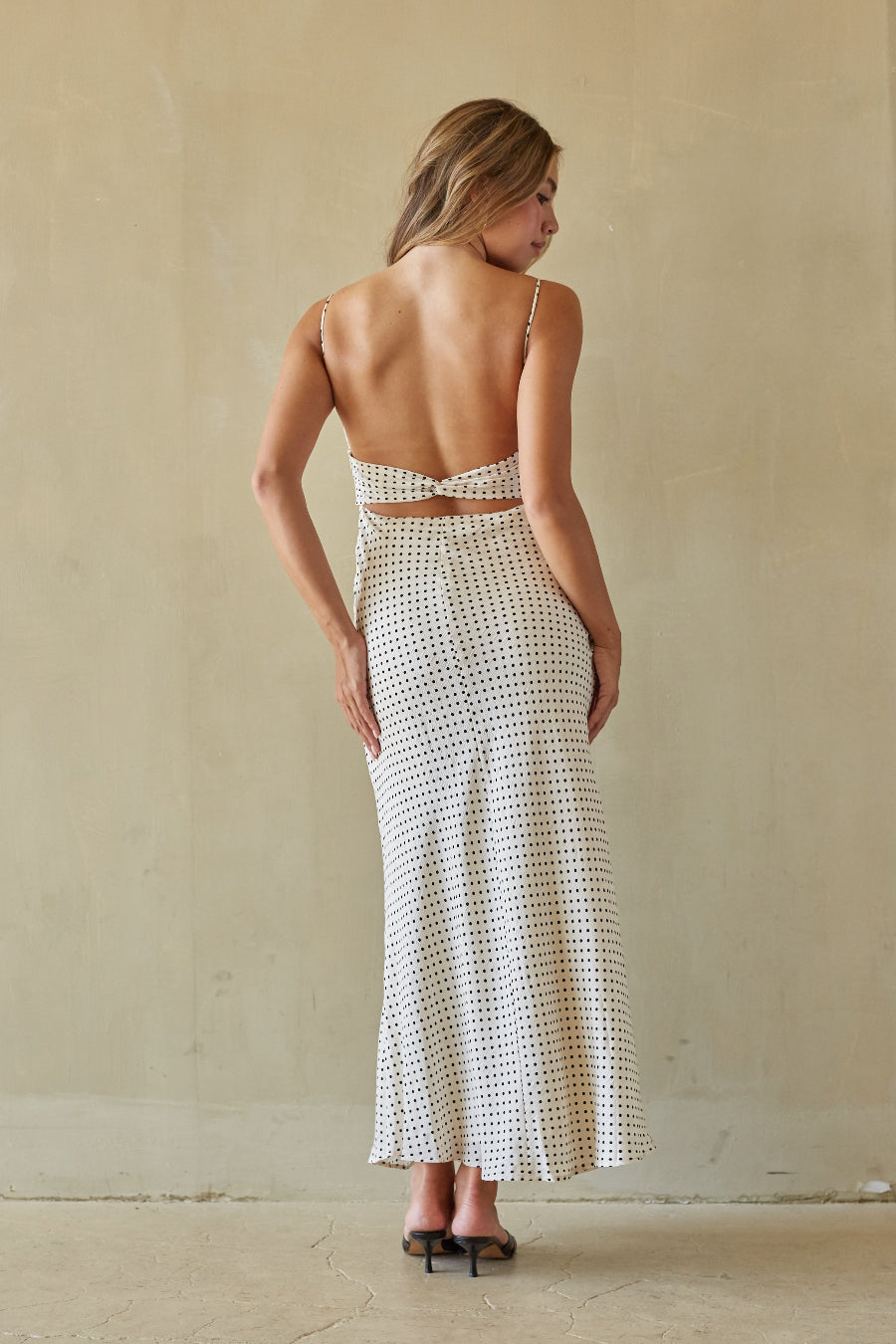 Woman wearing a black and white patterned dress against a plain background