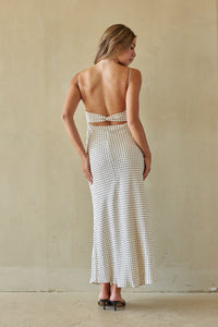 Woman wearing a black and white patterned dress against a plain background