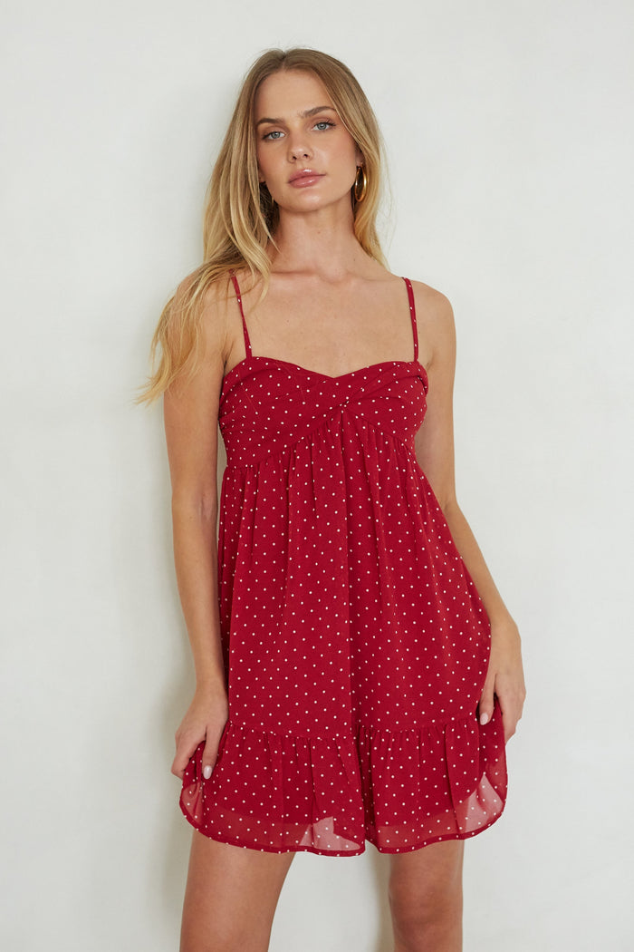 red-image | Woman wearing a red polka dot dress against a white background