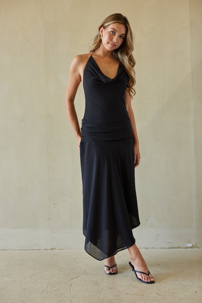 black-image | Woman wearing a black sleeveless top and skirt set against a plain background