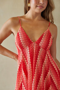 Red lace dress worn by a model against a neutral background