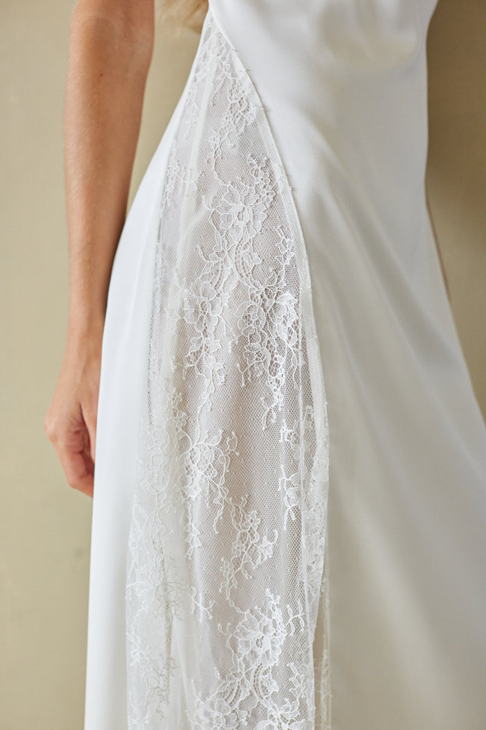 Close-up of a white lace-trimmed dress on a plain background