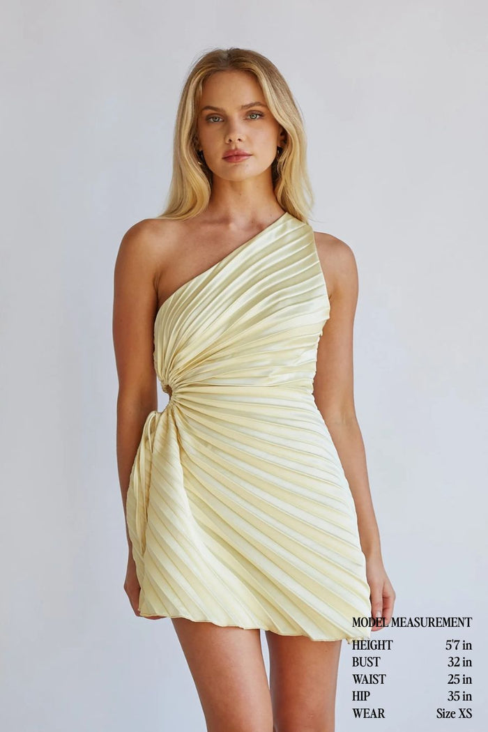 yellow-image | Woman wearing a light yellow one-shoulder dress against a plain background
