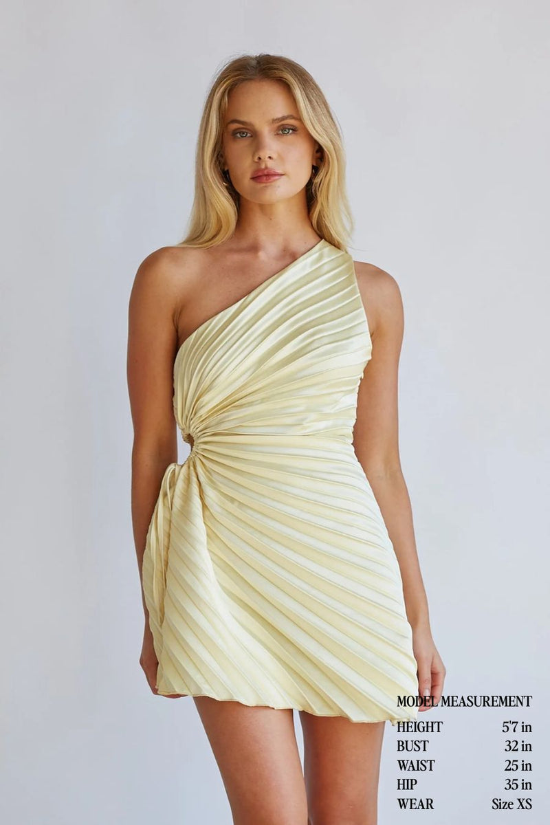 yellow-image | Woman wearing a light yellow one-shoulder dress against a plain background