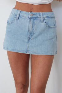 Light blue denim skirt worn by a person on a white background