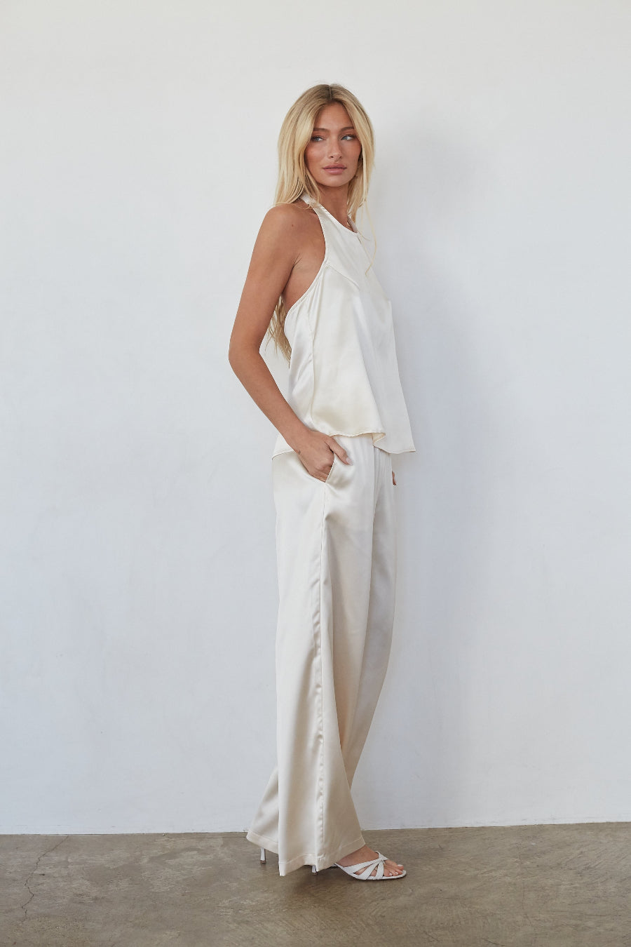 Woman wearing a white outfit against a plain background