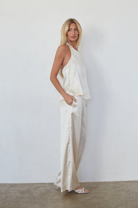 Woman wearing a white outfit against a plain background