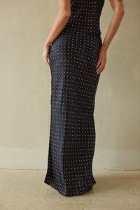 Black polka dot dress worn by a person against a neutral background