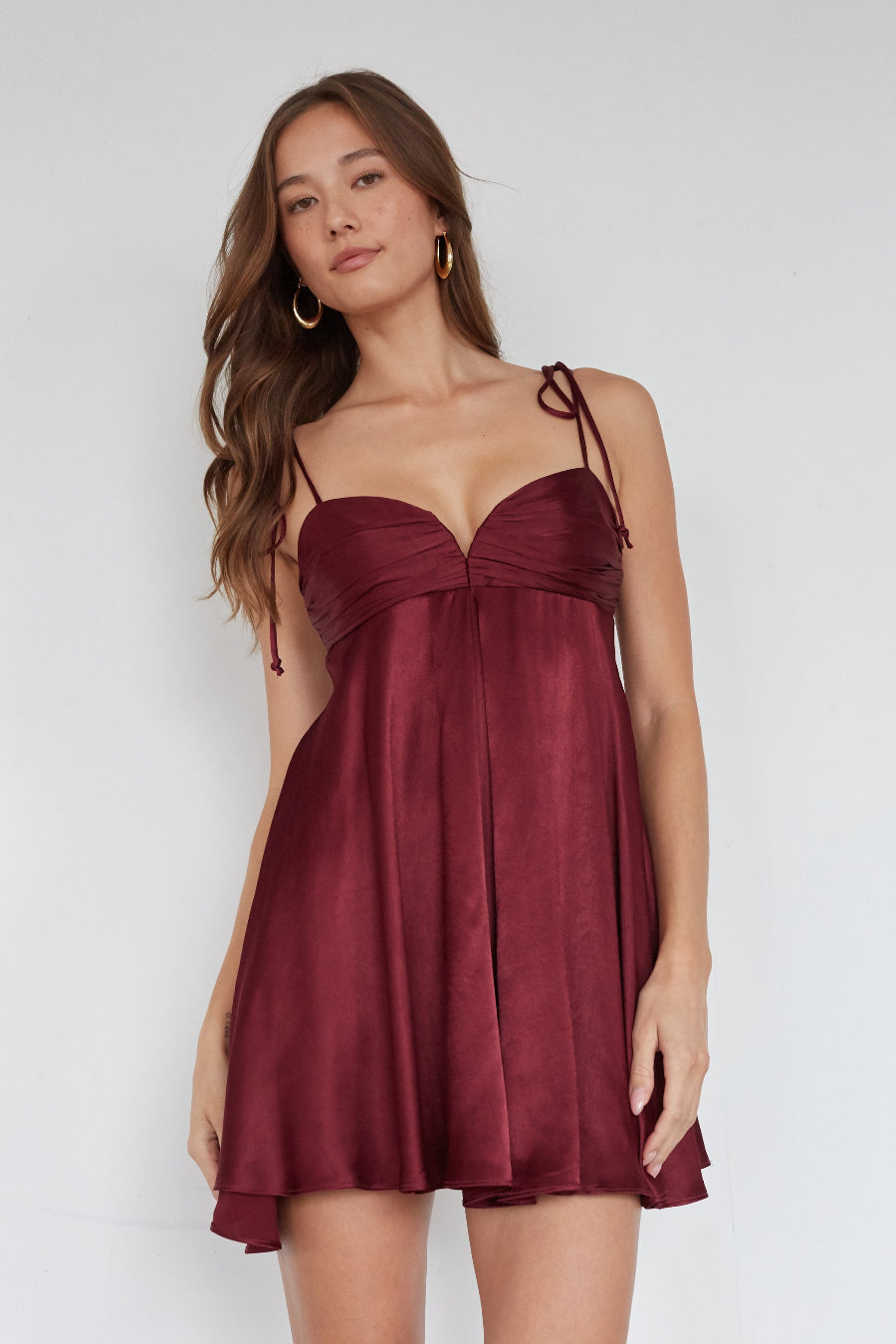 Woman wearing a burgundy dress against a white background