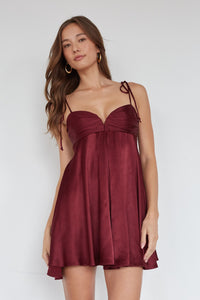 Woman wearing a burgundy dress against a white background