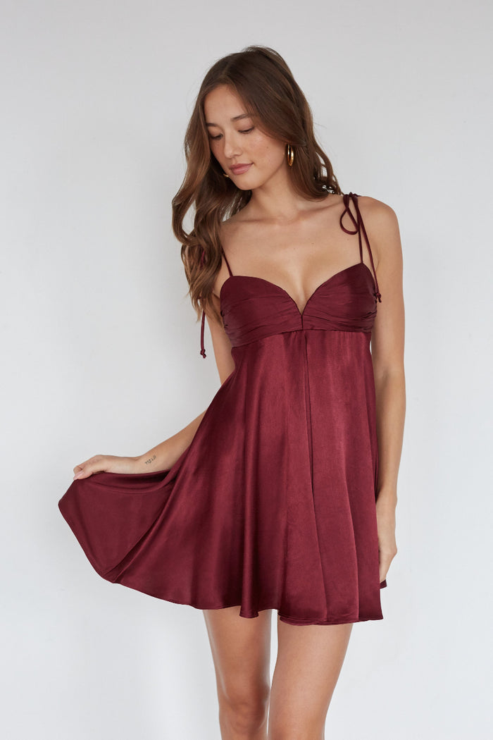 red-image | Woman wearing a burgundy dress against a white background