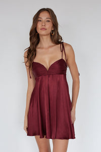 Woman wearing a burgundy dress against a white background