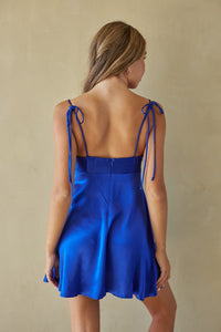 Blue dress with thin straps on a beige background