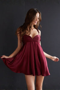 red-image | Woman wearing a burgundy dress against a dark background