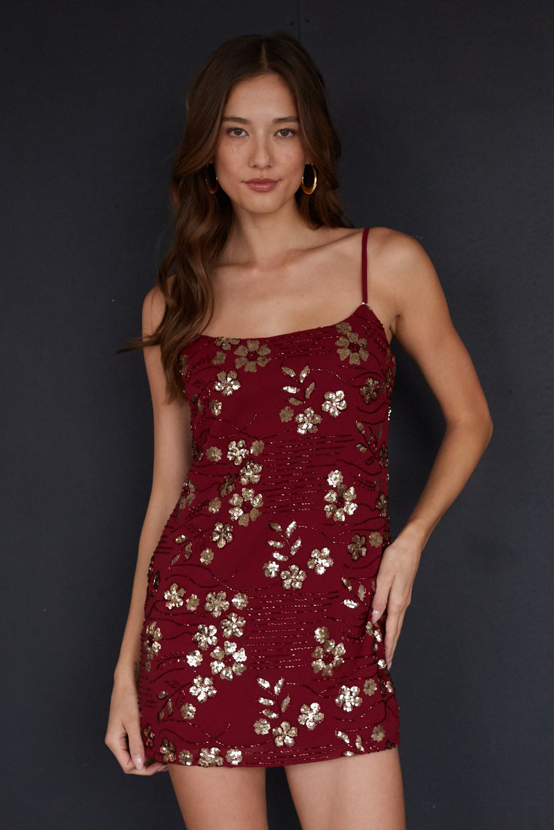 red-image | Woman wearing a red floral dress against a black background