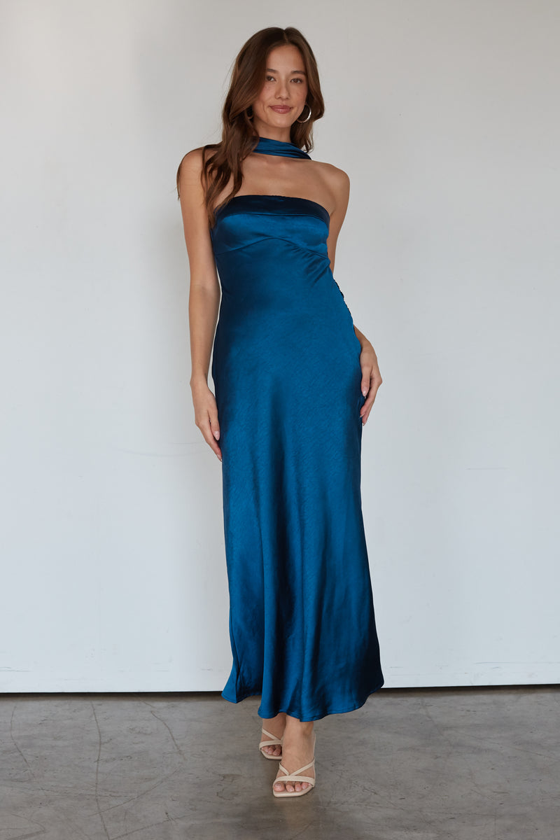 Woman wearing a blue strapless gown against a white background