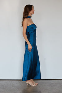 Woman wearing a blue strapless gown against a white background