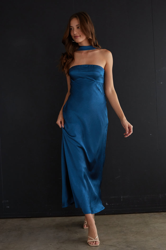 blue-image | Woman wearing a blue strapless dress against a black background