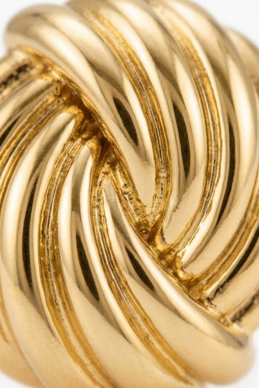 A close-up of a gold-colored twisted rope knot ring with a polished metallic finish, set against a plain white background.