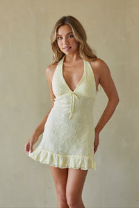 yellow-image | Woman wearing a light yellow lace dress against a plain background