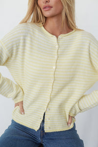 Woman wearing a yellow striped cardigan against a white background