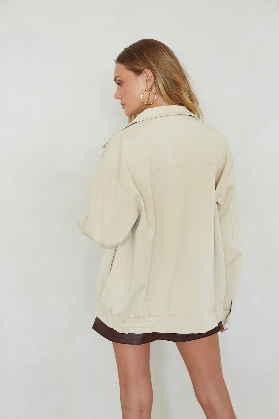 Woman wearing a beige jacket with a plain white background