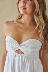 Woman wearing a white strapless dress with a cutout design.