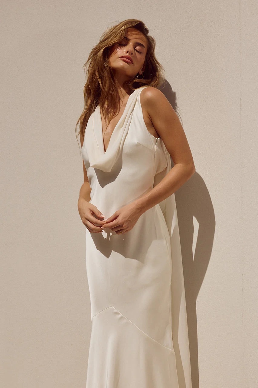 Woman wearing a white dress against a beige background