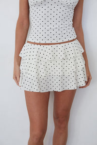 White polka dot dress with a plain background