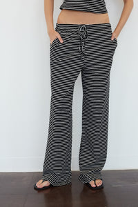 Black and white horizontally striped wide-leg pants with a drawstring waist, modeled with a matching striped crop top against a white wall.