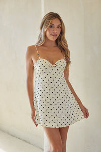 white-image | Woman wearing a polka dot slip dress against a plain background