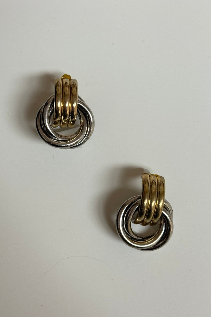 Pair of earrings with interlocking rings on a light gray background