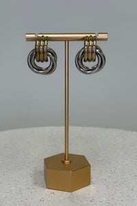 Gold and silver earring display stand on a gray background