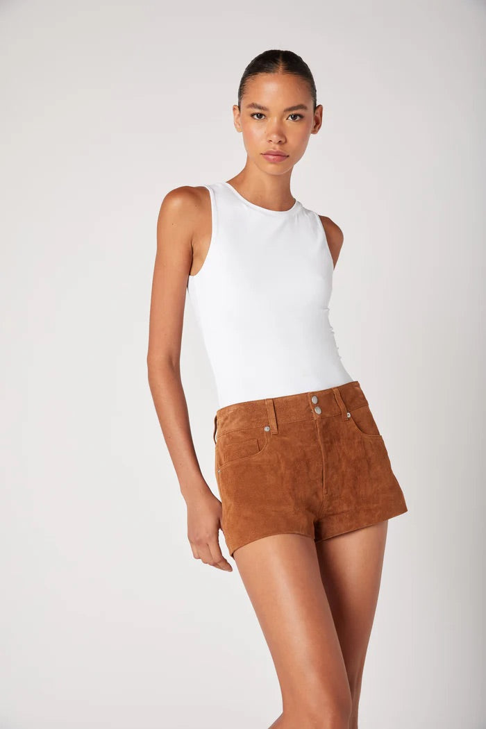 Woman wearing a white sleeveless top and brown shorts on a white background