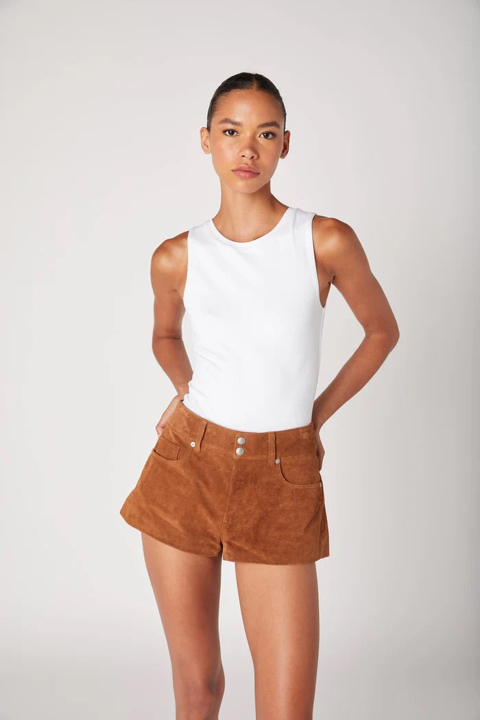 Woman wearing a white sleeveless top and brown shorts on a white background