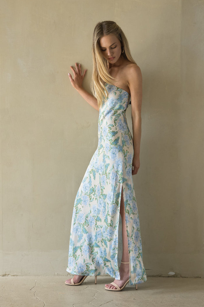Woman wearing a floral strapless dress with a slit in a minimalistic setting