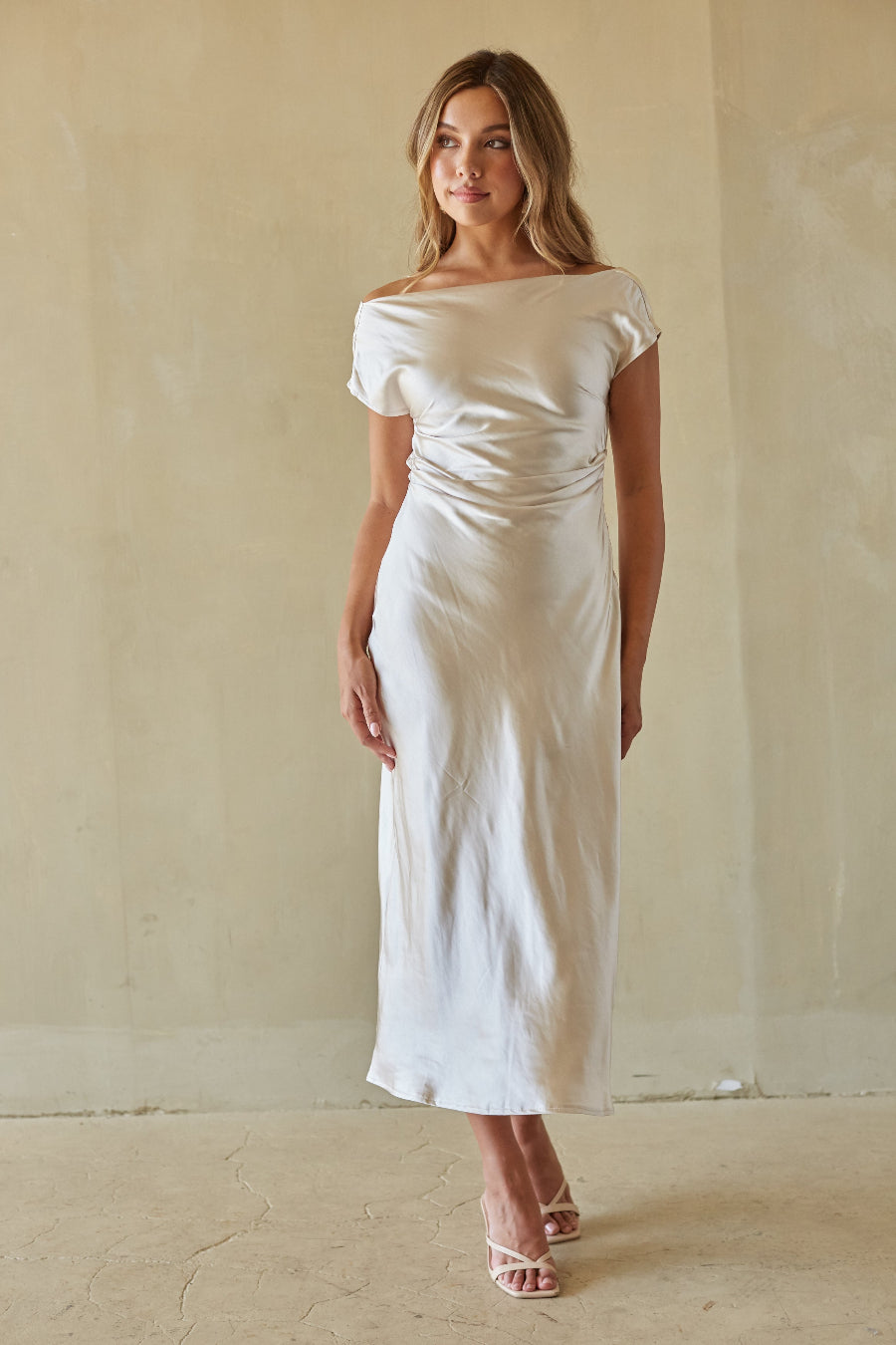 white-image | Woman wearing a white off-shoulder dress against a plain background